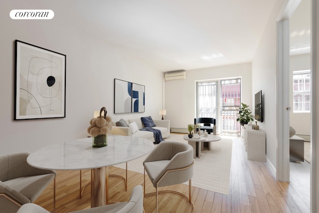 interior space with baseboards, visible vents, a wall mounted air conditioner, and light wood-style floors