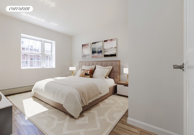 bedroom with a baseboard heating unit, baseboards, visible vents, and light wood finished floors