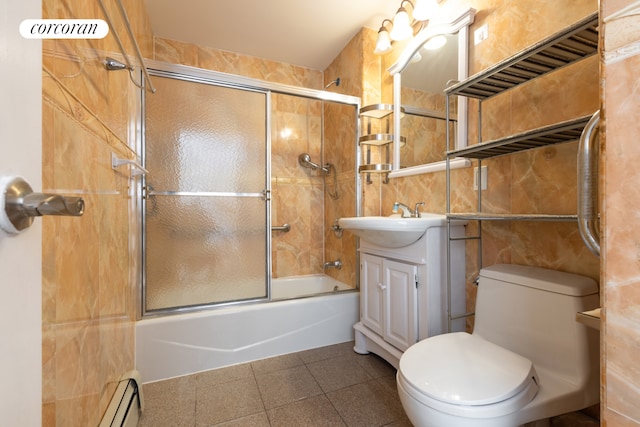 full bathroom featuring a baseboard heating unit, toilet, vanity, and bath / shower combo with glass door