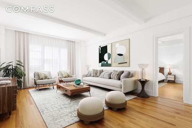 living room with light wood-type flooring, baseboards, and beamed ceiling