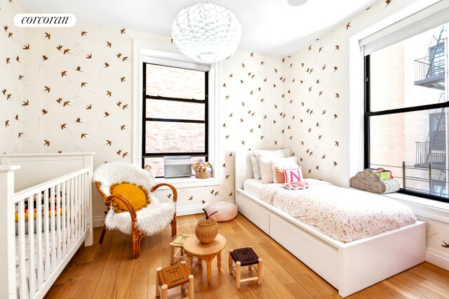 299 Riverside Dr Unit 3C, New York City, NY 10025 - bedroom with wallpapered walls, light wood-type flooring, multiple windows, and baseboards