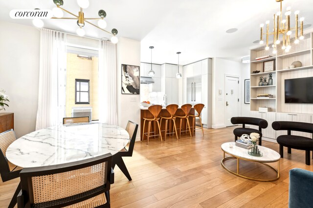 living room featuring a chandelier, light wood finished floors, and visible vents