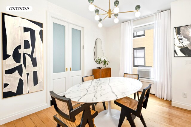 dining room with a chandelier, light wood finished floors, a dry bar, and visible vents