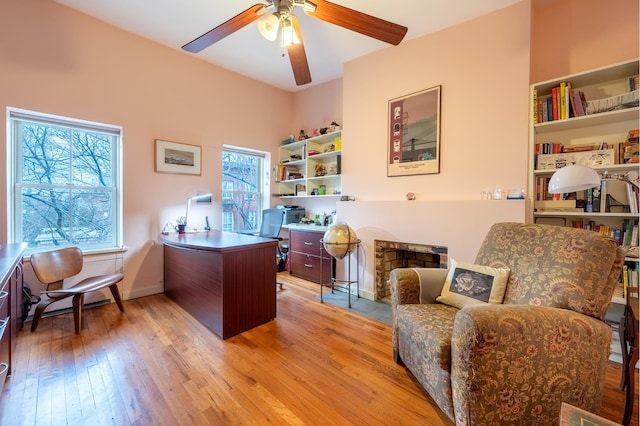 office area with baseboards, a ceiling fan, and wood-type flooring