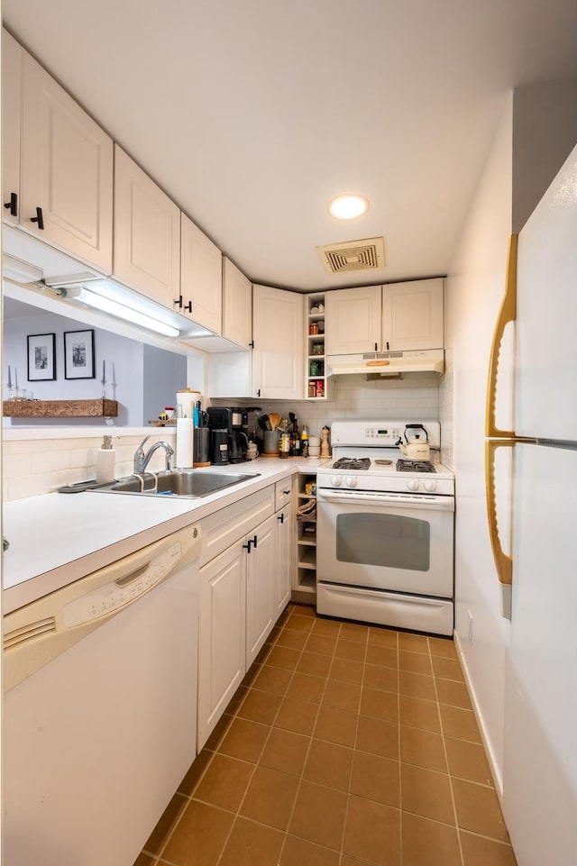 kitchen featuring tasteful backsplash, visible vents, white appliances, white cabinetry, and a sink