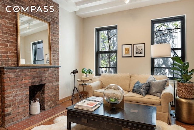 living room with track lighting, a brick fireplace, and baseboards