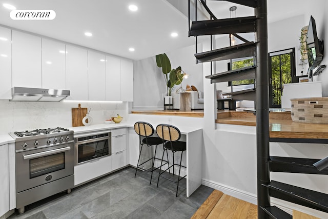 kitchen with under cabinet range hood, visible vents, white cabinets, appliances with stainless steel finishes, and modern cabinets