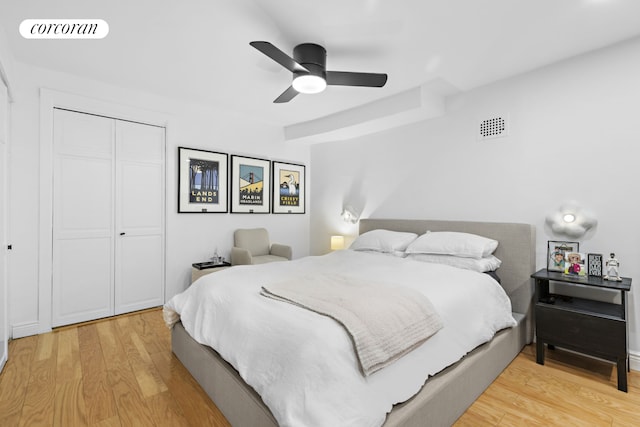 bedroom with a ceiling fan, light wood-type flooring, a closet, and visible vents