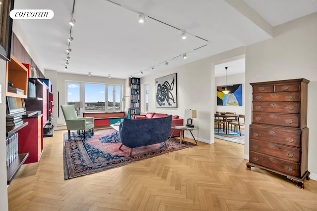 living area featuring baseboards, rail lighting, and visible vents