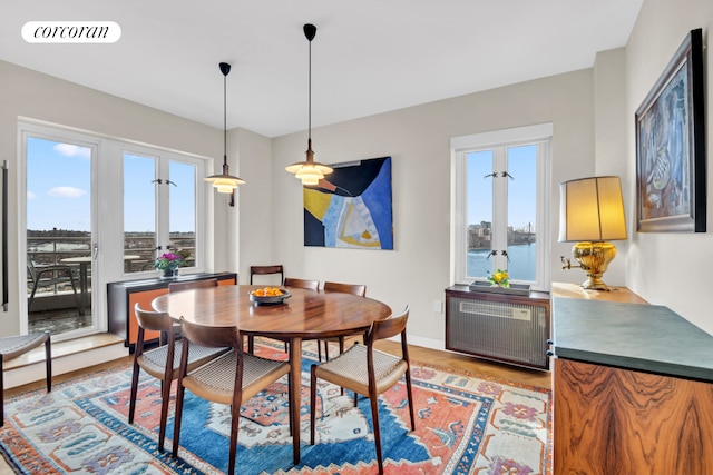 dining space featuring visible vents, plenty of natural light, radiator heating unit, and light wood finished floors