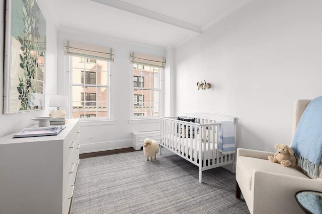 bedroom featuring a nursery area, ornamental molding, carpet, and baseboards