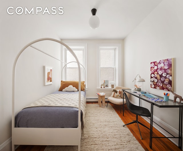 bedroom with wood finished floors and baseboards