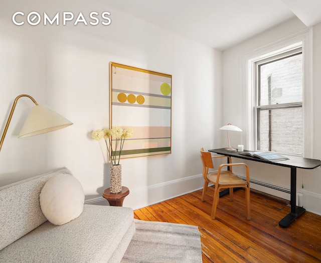 home office with wood-type flooring, baseboards, and baseboard heating