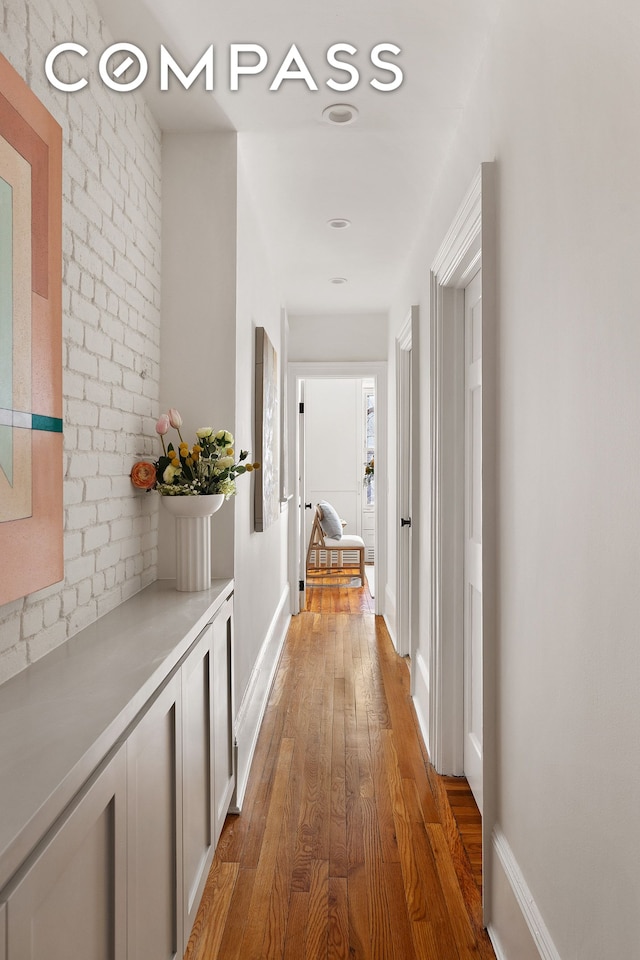 hall featuring hardwood / wood-style floors and baseboards