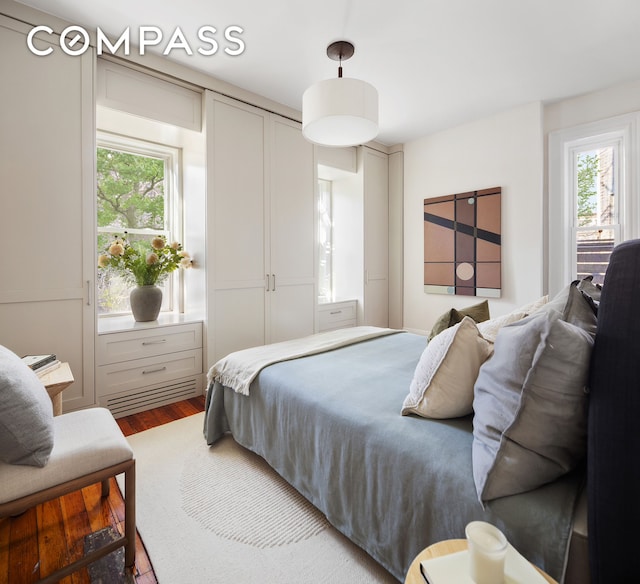 bedroom featuring multiple windows and wood finished floors