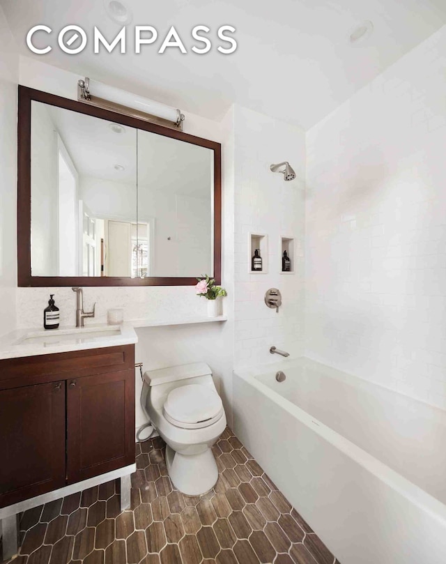 full bathroom featuring toilet, vanity, decorative backsplash, and shower / bathtub combination