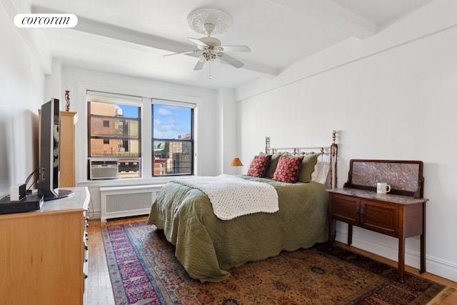 600 W 111th St Unit 10D, New York City, NY 10025 - bedroom with radiator, beam ceiling, wood finished floors, cooling unit, and a ceiling fan