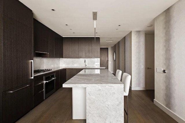 kitchen featuring a sink, modern cabinets, a kitchen island, and oven