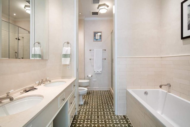 bathroom with toilet, crown molding, and a sink