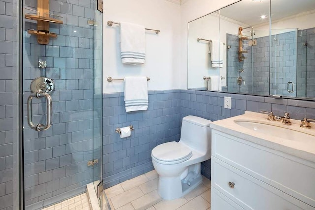 bathroom featuring a stall shower, toilet, tile walls, vanity, and tile patterned flooring