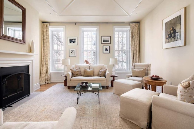 living area with a fireplace with flush hearth and baseboards