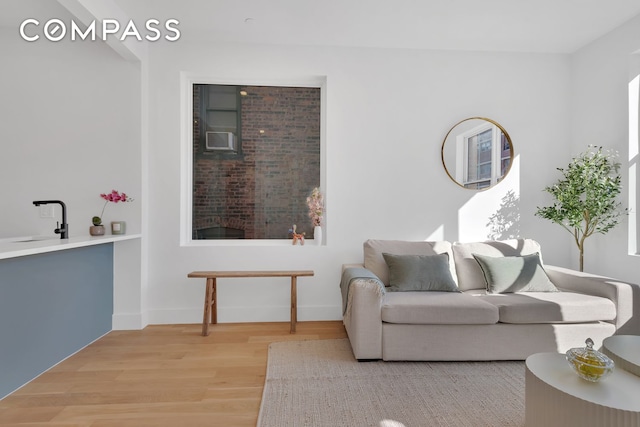 living area featuring baseboards and light wood-style floors