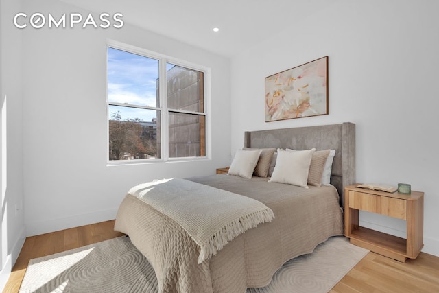 bedroom with light wood finished floors, recessed lighting, and baseboards