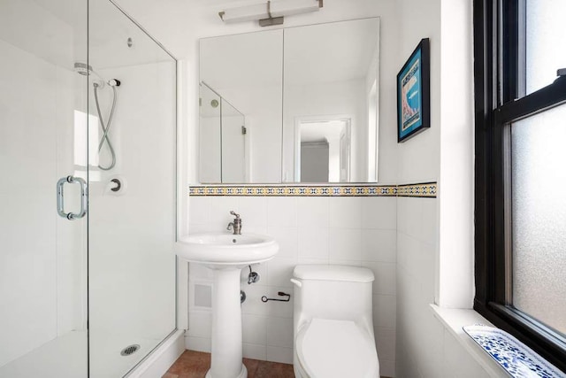 full bathroom featuring toilet, a stall shower, and tile walls