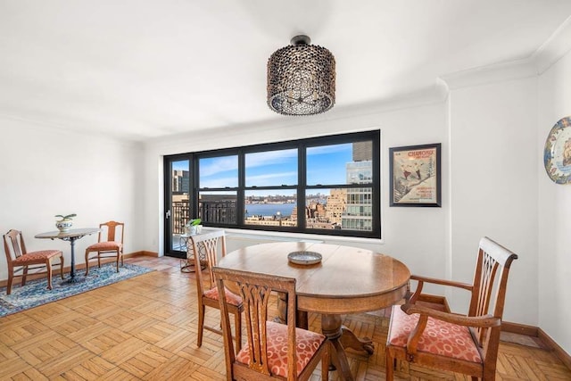 dining area with baseboards and crown molding