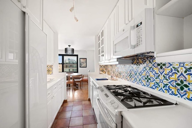 kitchen featuring light countertops, white appliances, backsplash, and white cabinetry