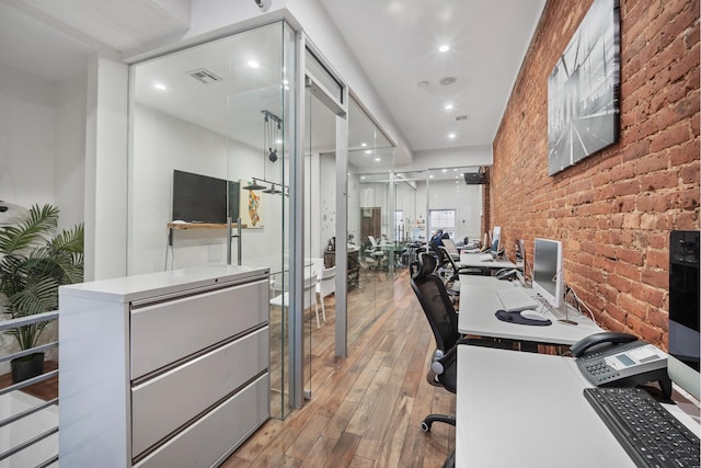 office area featuring visible vents, recessed lighting, light wood-style flooring, and brick wall