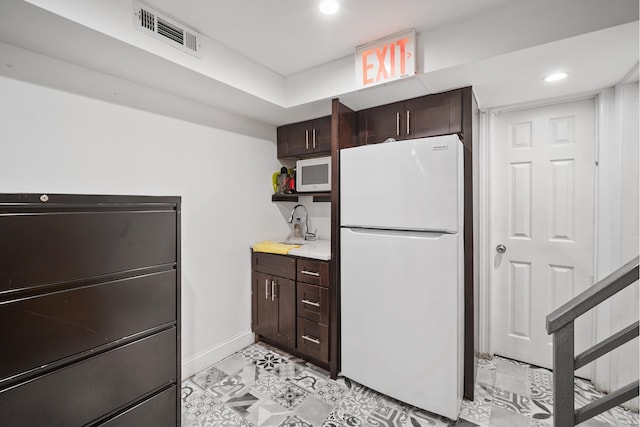 kitchen featuring visible vents, dark brown cabinetry, white appliances, baseboards, and recessed lighting