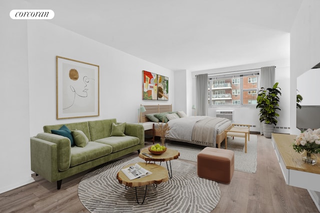 bedroom featuring a baseboard radiator, visible vents, wood finished floors, and a wall mounted AC