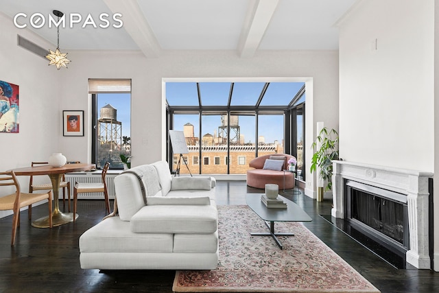 living area with beam ceiling, a city view, dark wood finished floors, and a fireplace with flush hearth