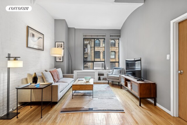 living area featuring baseboards, visible vents, and hardwood / wood-style floors