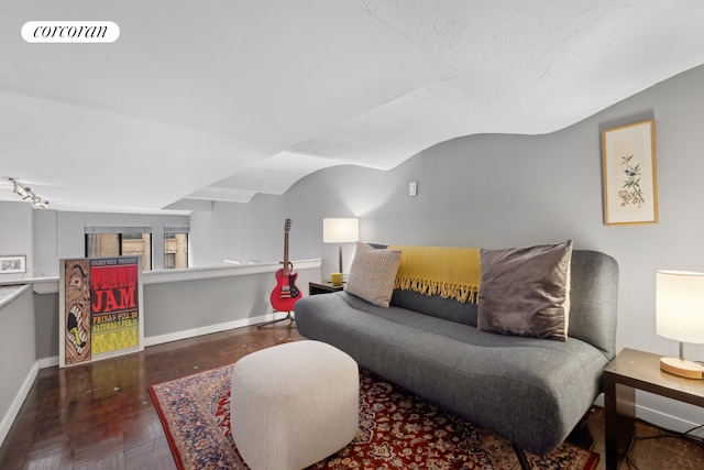 living room featuring lofted ceiling, baseboards, visible vents, and wood finished floors