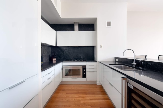 kitchen with wall oven, visible vents, white cabinets, wine cooler, and a sink