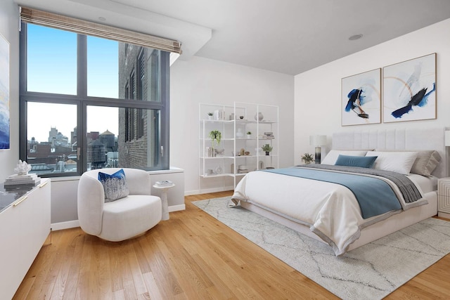 bedroom featuring wood-type flooring, multiple windows, and baseboards