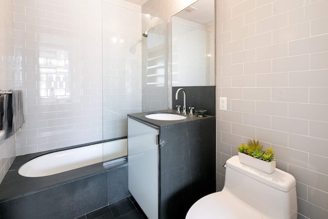 full bath featuring toilet, tile walls, vanity, and tile patterned floors