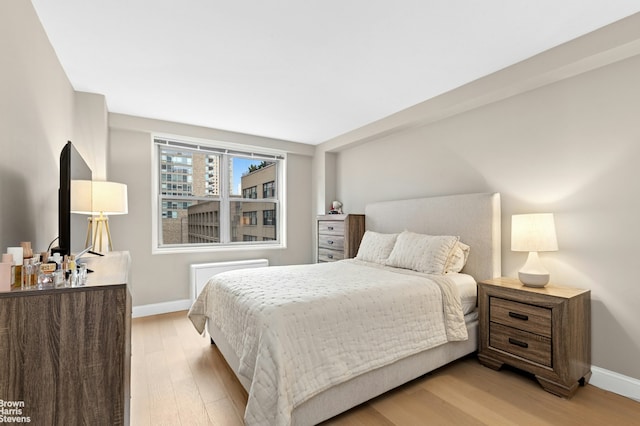 bedroom with baseboards and light wood-style flooring