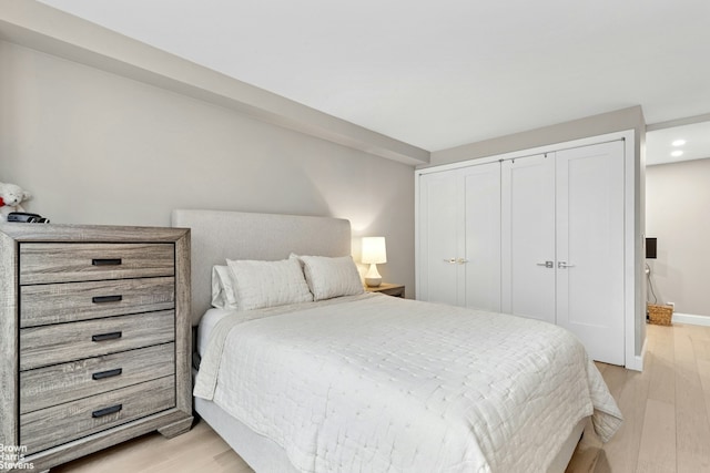 bedroom featuring baseboards, a closet, recessed lighting, and light wood-style flooring