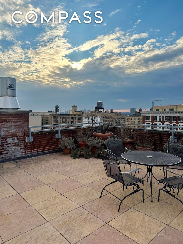 view of patio with outdoor dining area and a view of city