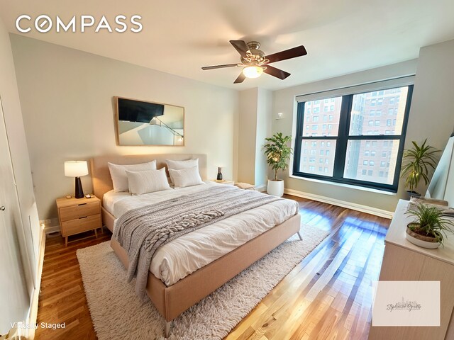 bedroom with ceiling fan, baseboards, and wood finished floors