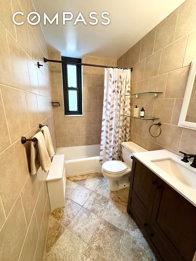 bathroom featuring toilet, tile walls, shower / bath combo, and vanity