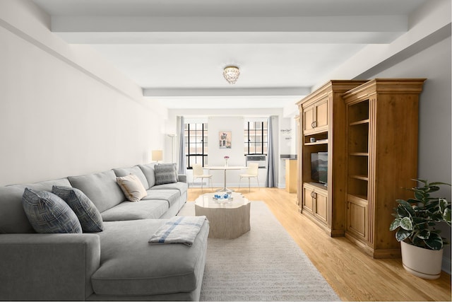 living area featuring beam ceiling and light wood-style flooring