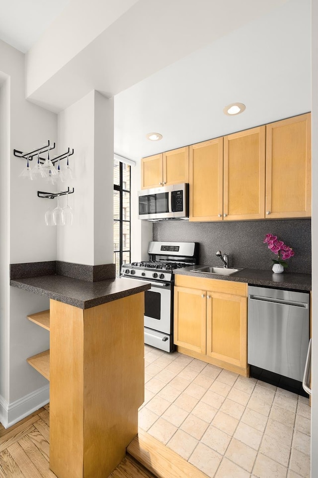 kitchen with dark countertops, open shelves, light brown cabinets, and appliances with stainless steel finishes