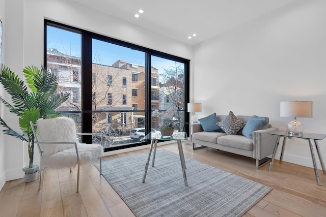 living area featuring recessed lighting, wood finished floors, and baseboards