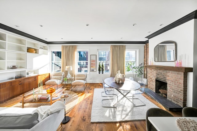 living room with ornamental molding, a fireplace, and hardwood / wood-style floors