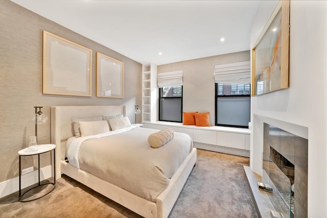 carpeted bedroom featuring recessed lighting and a tiled fireplace