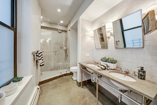 bathroom with a baseboard heating unit, a sink, a shower stall, and toilet